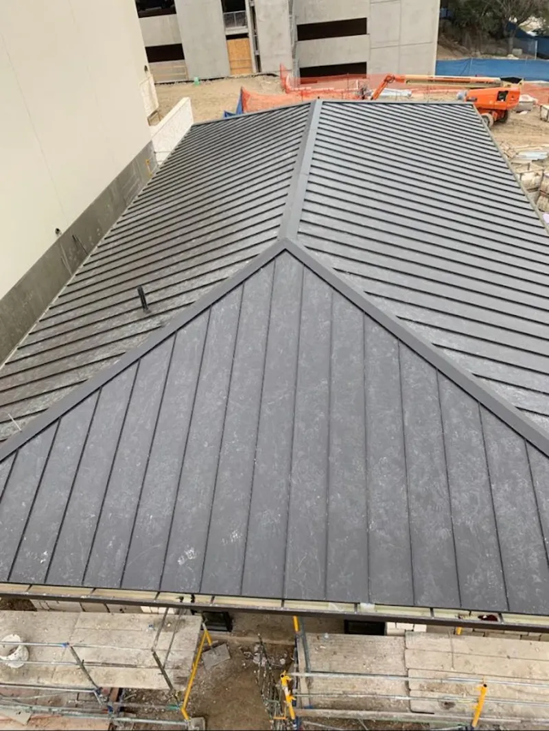 Commercial metal roof construction with crane equipment in Maplewood